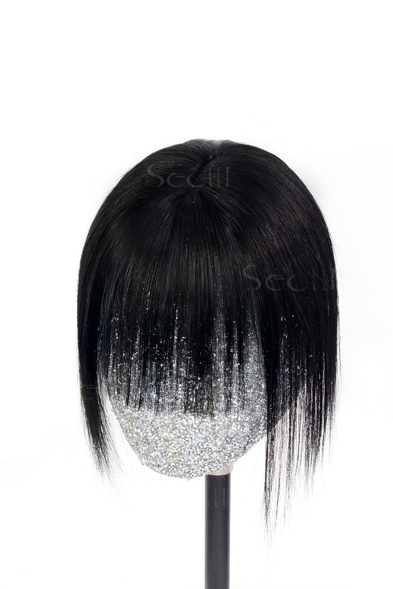 A mannequin head showcasing a dark black human hair topper with bangs.