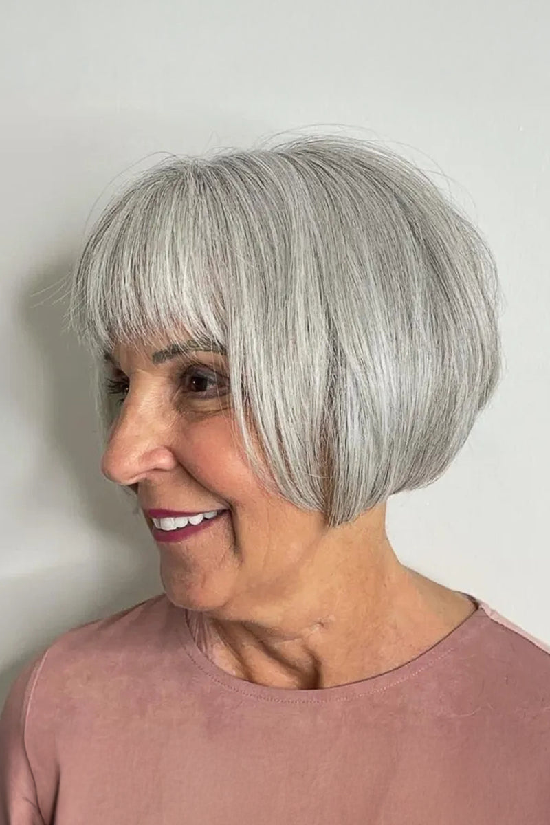 Woman wearing a sandy blonde short bob wig with full bangs, front view, striped top