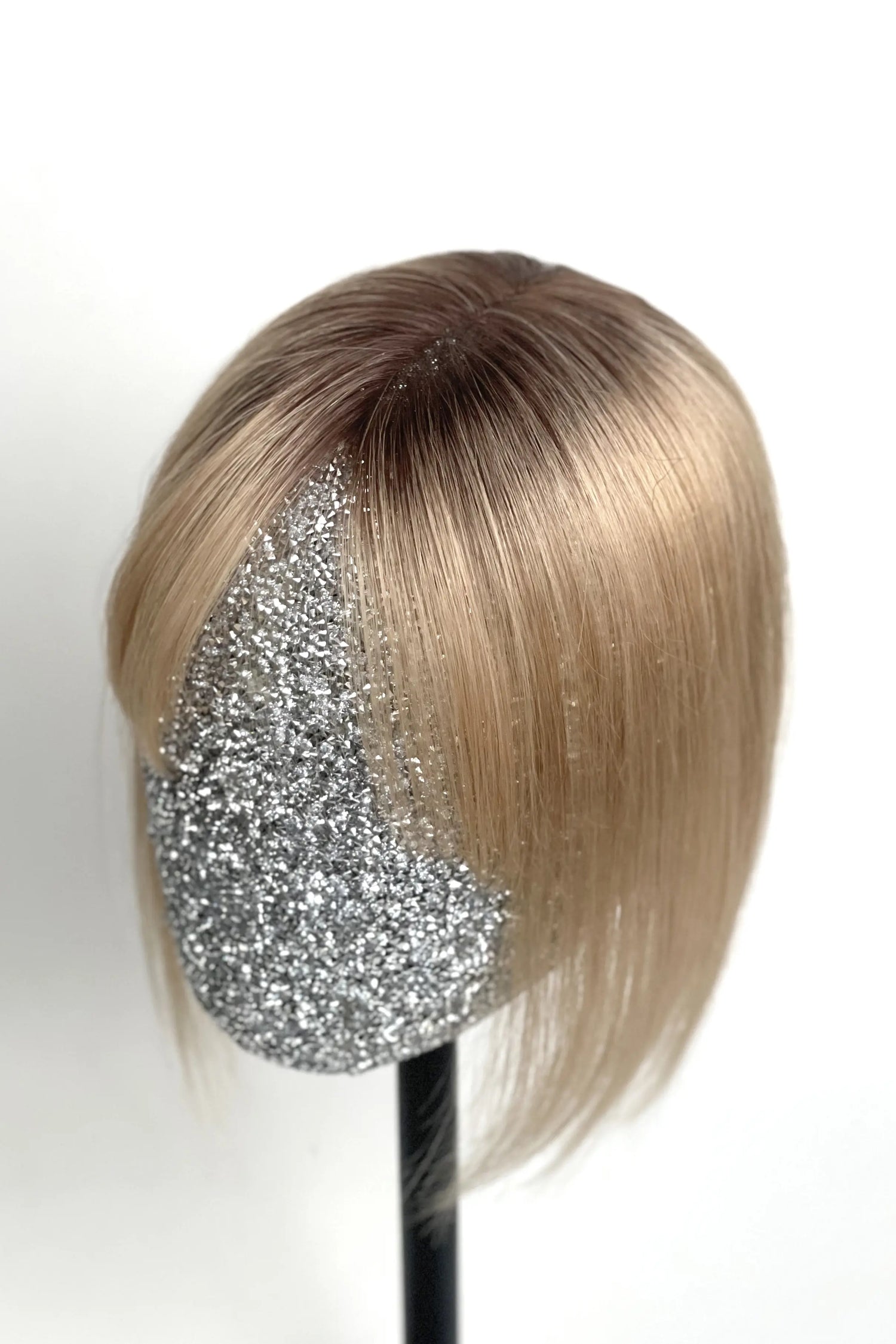 A handcrafted human hair topper with bangs, shaded with medium brown, displayed on a mannequin head.