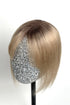 A handcrafted human hair topper with bangs, shaded with medium brown, displayed on a mannequin head.