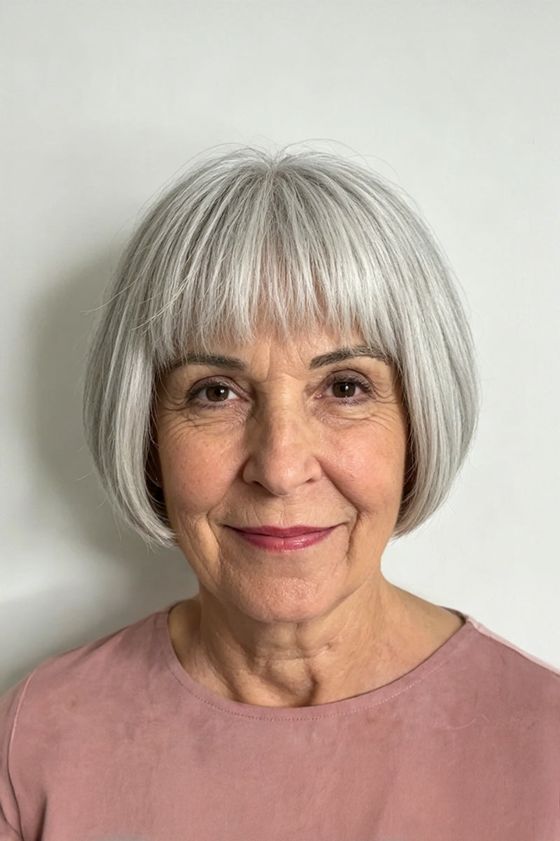 Woman wearing a sandy blonde short bob wig with full bangs, side profile view, striped top