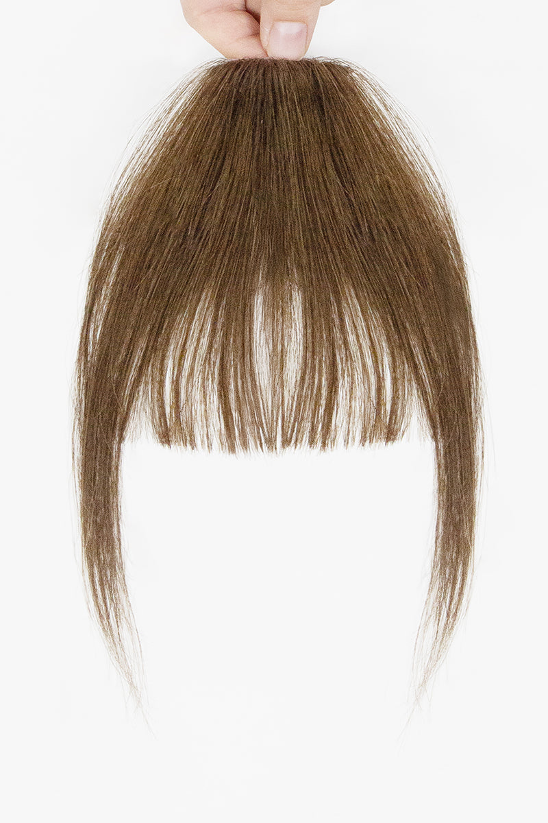 Brown hair extension held by a hand on a white background