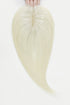 Blonde hair extensions held by hands on a white background