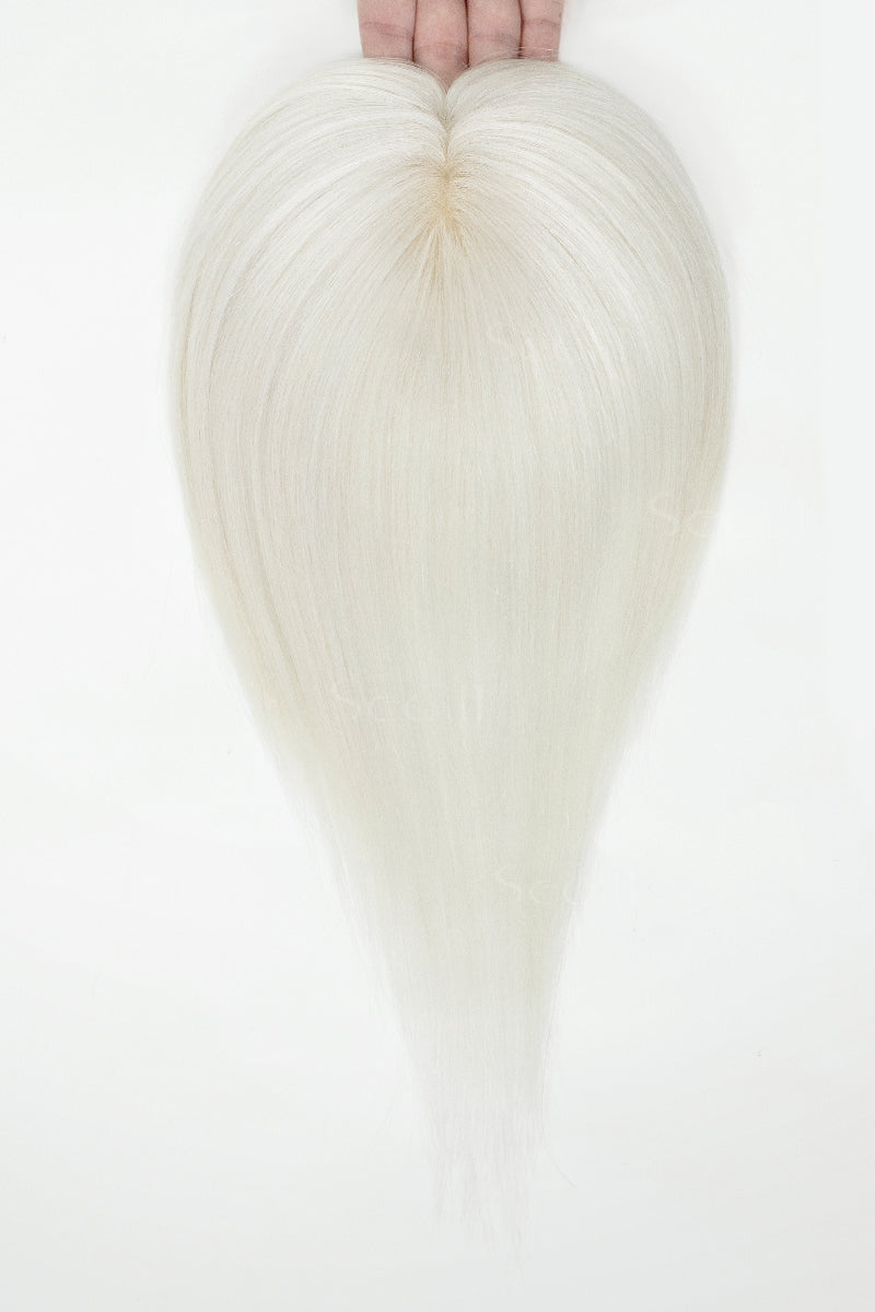White topper held by hands against a white background