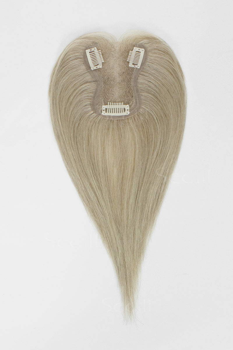 Full underside view of a beige blonde hair topper showing the mesh base, three clips and hair length.