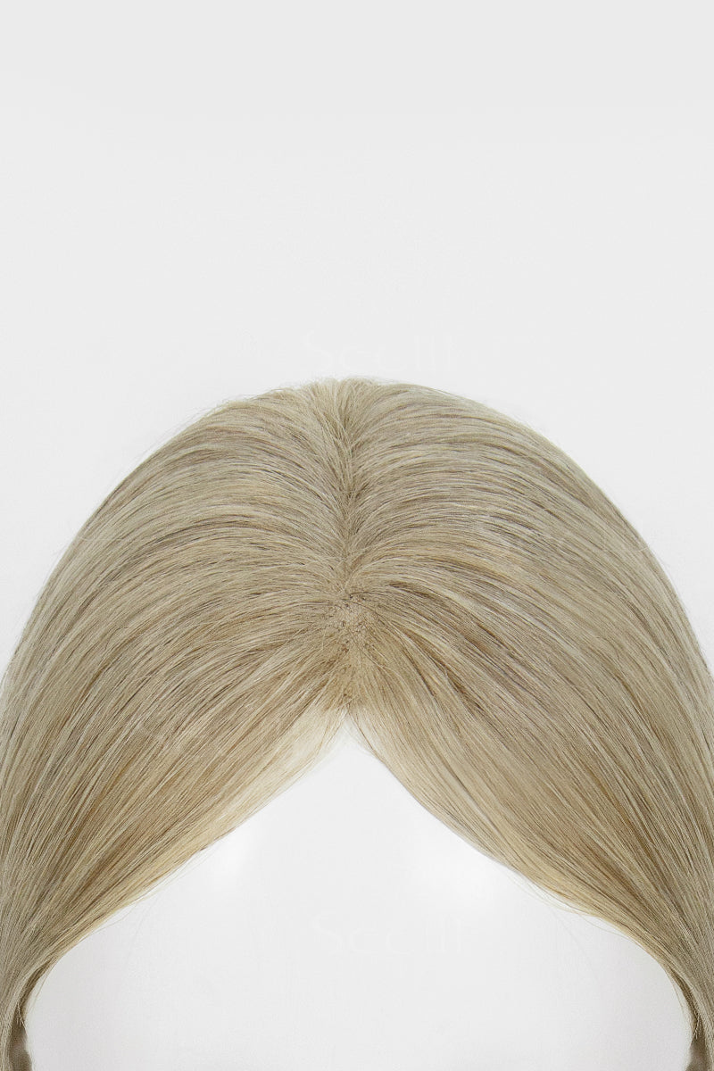 Close-up of the center part and swept-back front strands on a beige blonde hair topper.