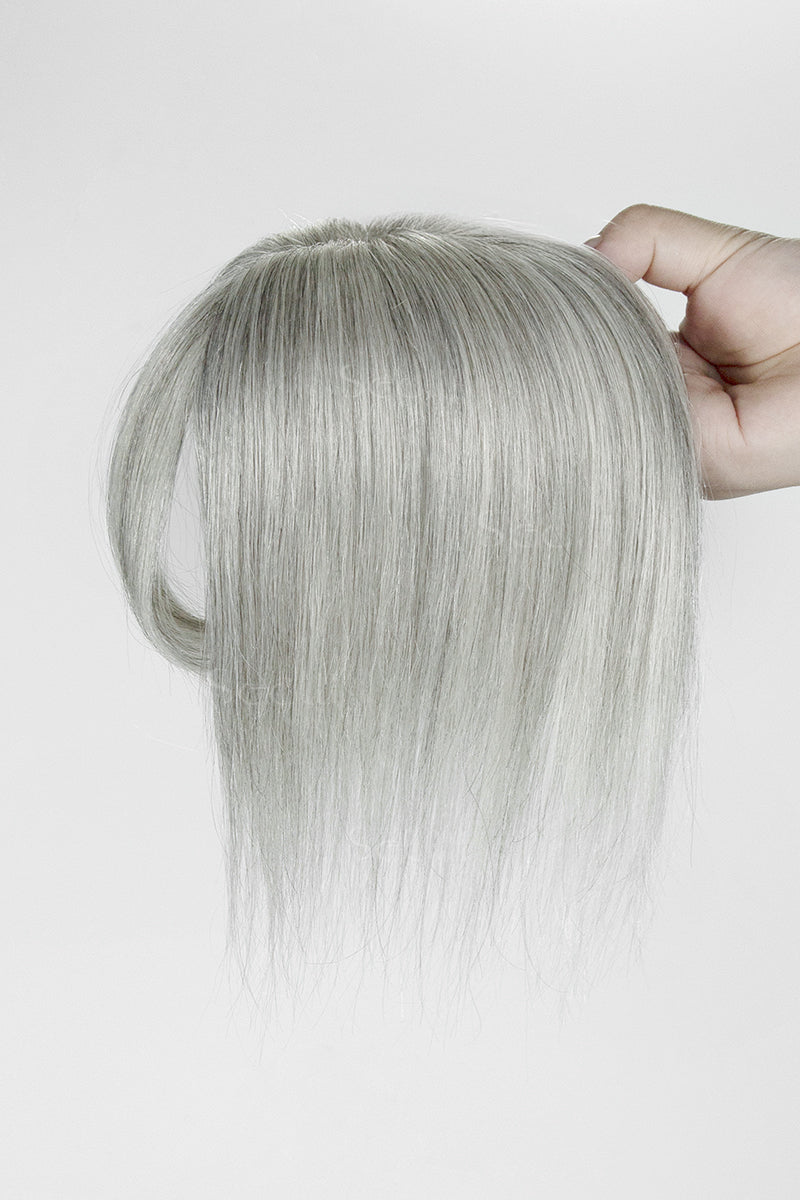 Light Grey hair topper held by a hand against a white background