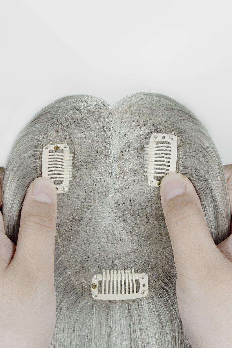 Light Grey hair topper with clips held by a person&
