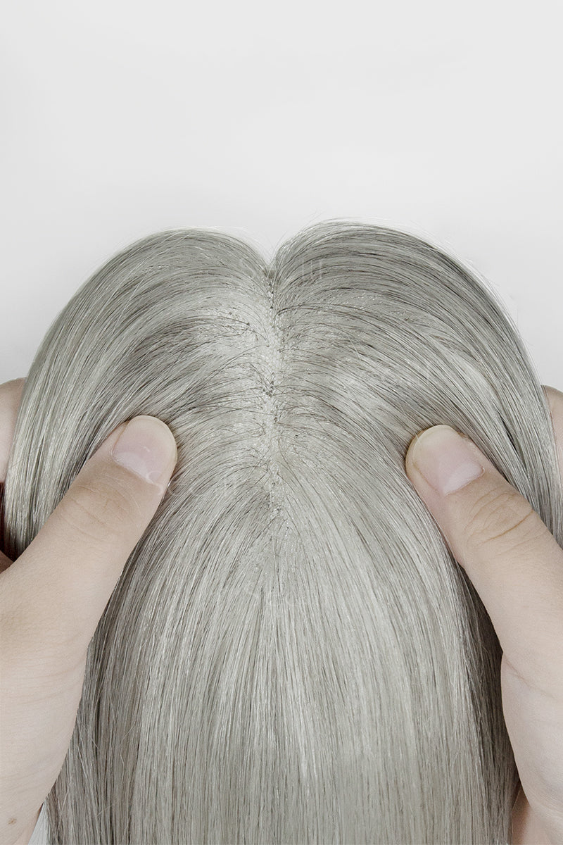 Close-up of a person holding Light Grey hair strands against a white background