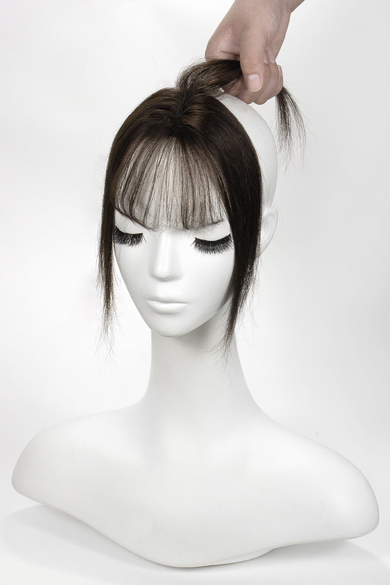 Mannequin head with a brown Topper and bangs on a white background