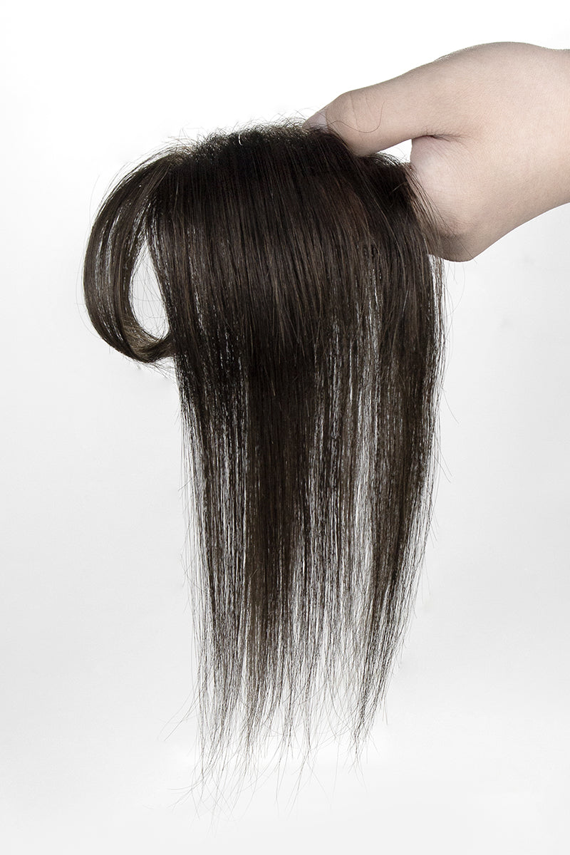 Hand holding a bundle of straight brown hair Topper on a white background