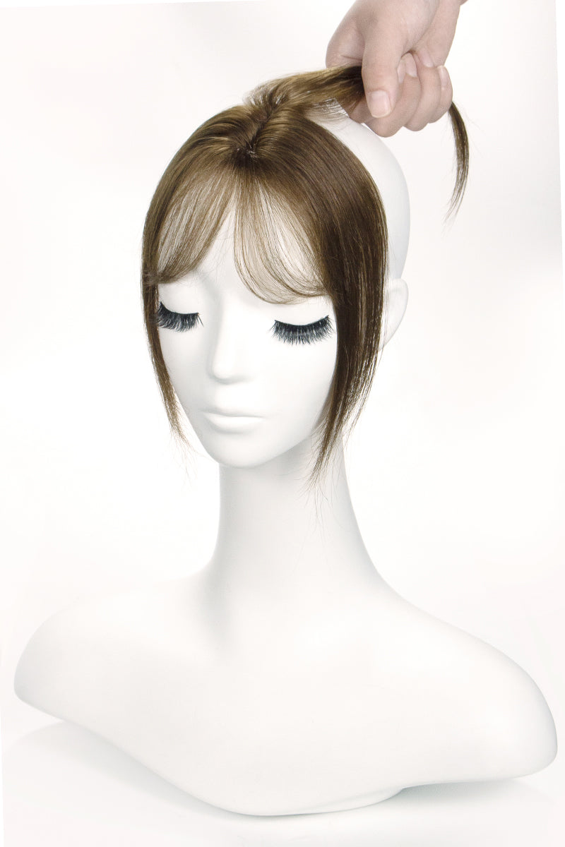 Mannequin head with a brown topper on a white background