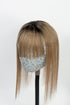 A mannequin head displaying a handmade human hair topper with bangs, featuring a natural black root and medium ash brown color.