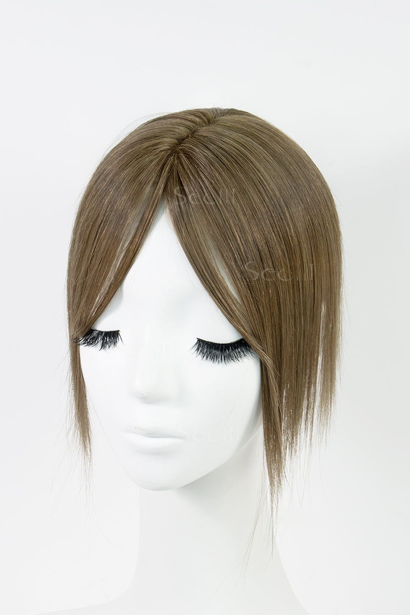 A mannequin head showcasing a light chestnut brown human hair topper with bangs.