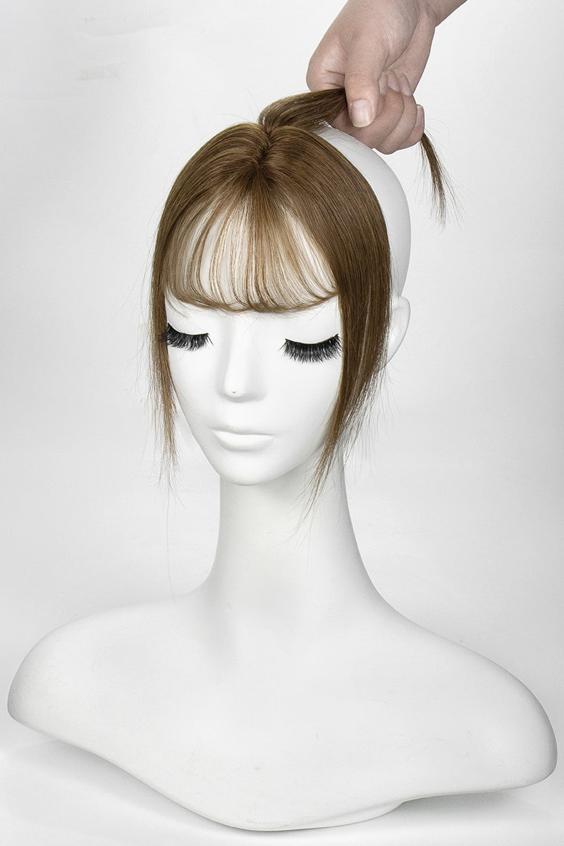 Mannequin head with a brown topper and bangs on a white background