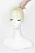 A blonde wig with straight bangs displayed on a white mannequin bust, with a hand lifting the hair at the top against a plain white background.