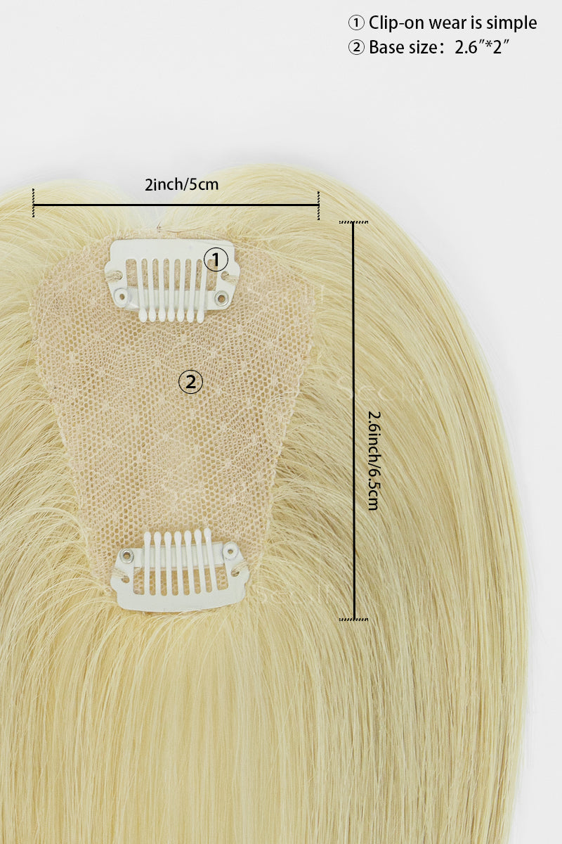 A close-up of a clip-in hair extension piece with two white plastic clips attached to a beige lace base, shown with measurement annotations indicating 2 inch width and 2.6 inch height on a light gray background.