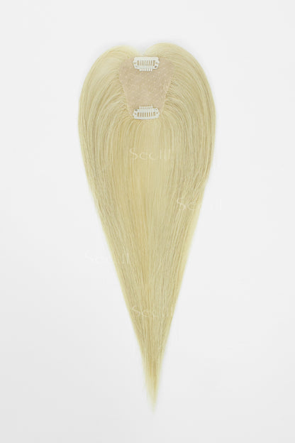 A heart-shaped blonde hair extension piece with a natural-looking beige attachment band, displayed against a plain white background.