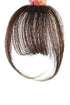 A hand holding a piece of human hair bangs accessory against a white background.