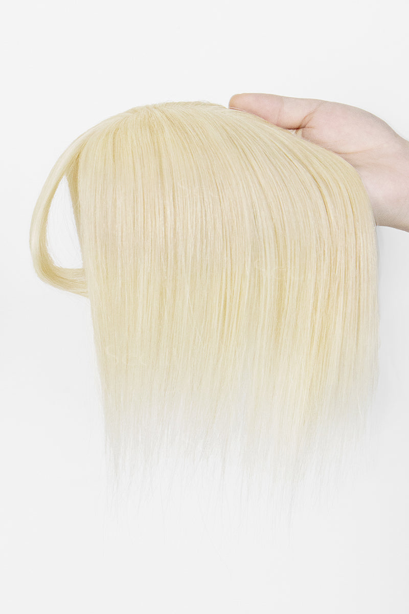 A hand holding a straight, shoulder-length blonde wig against a plain white background.