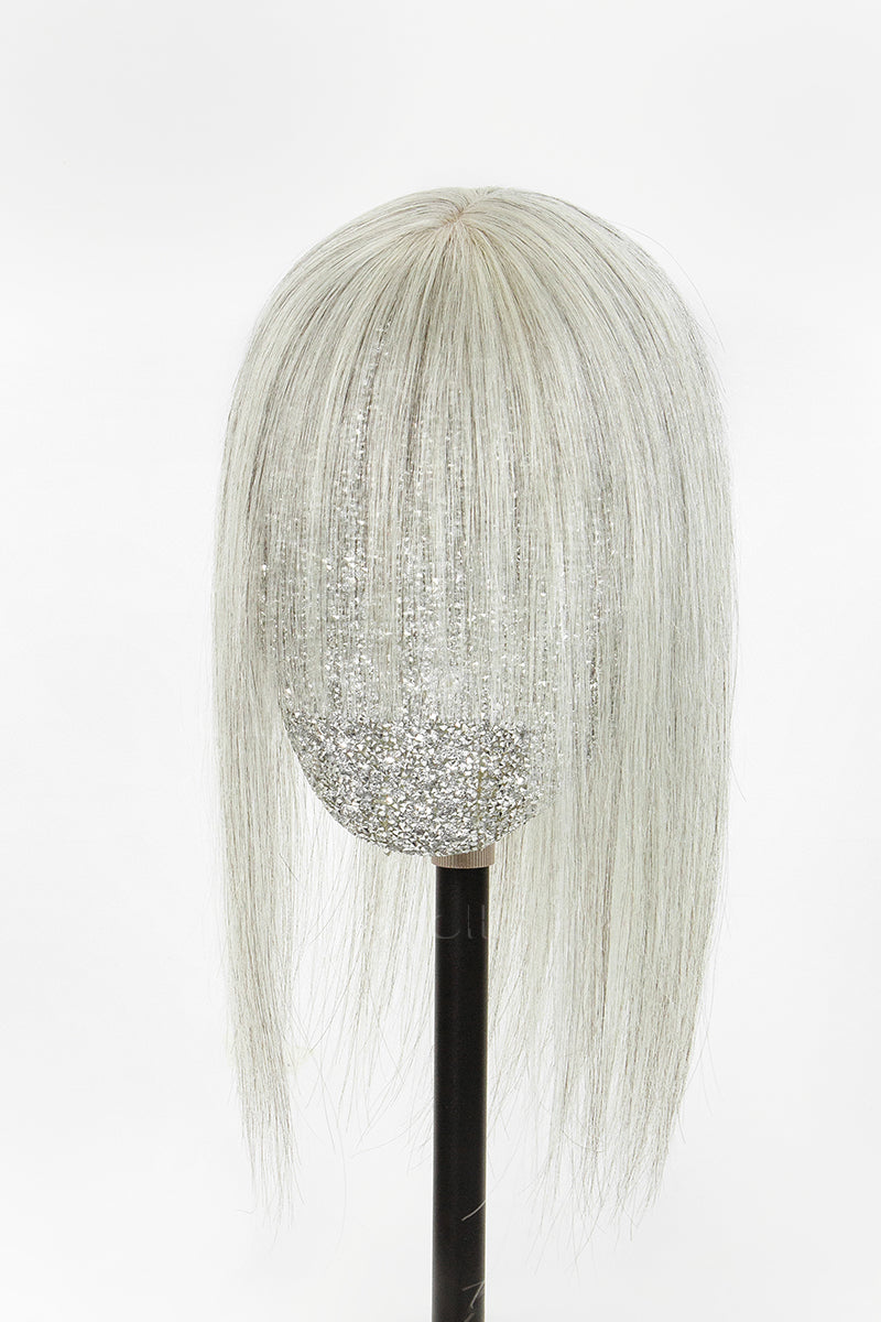 A long, straight, platinum blonde wig with subtle silver glitter strands integrated through the hair, displayed on a black mannequin head against a plain white background.