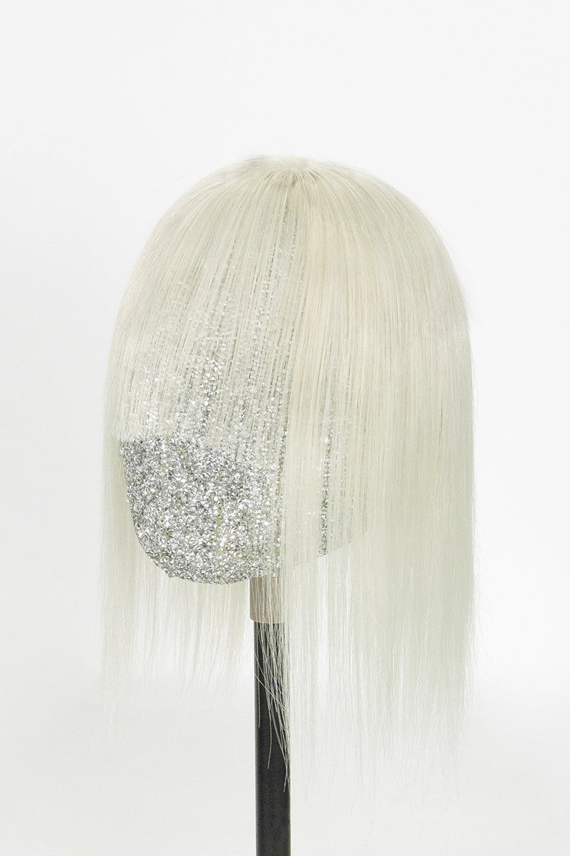 White wig with a silver glittery bow on a white background