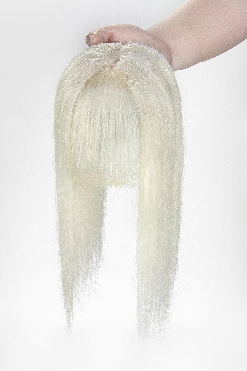 Blonde hair extension held by a hand on a white background