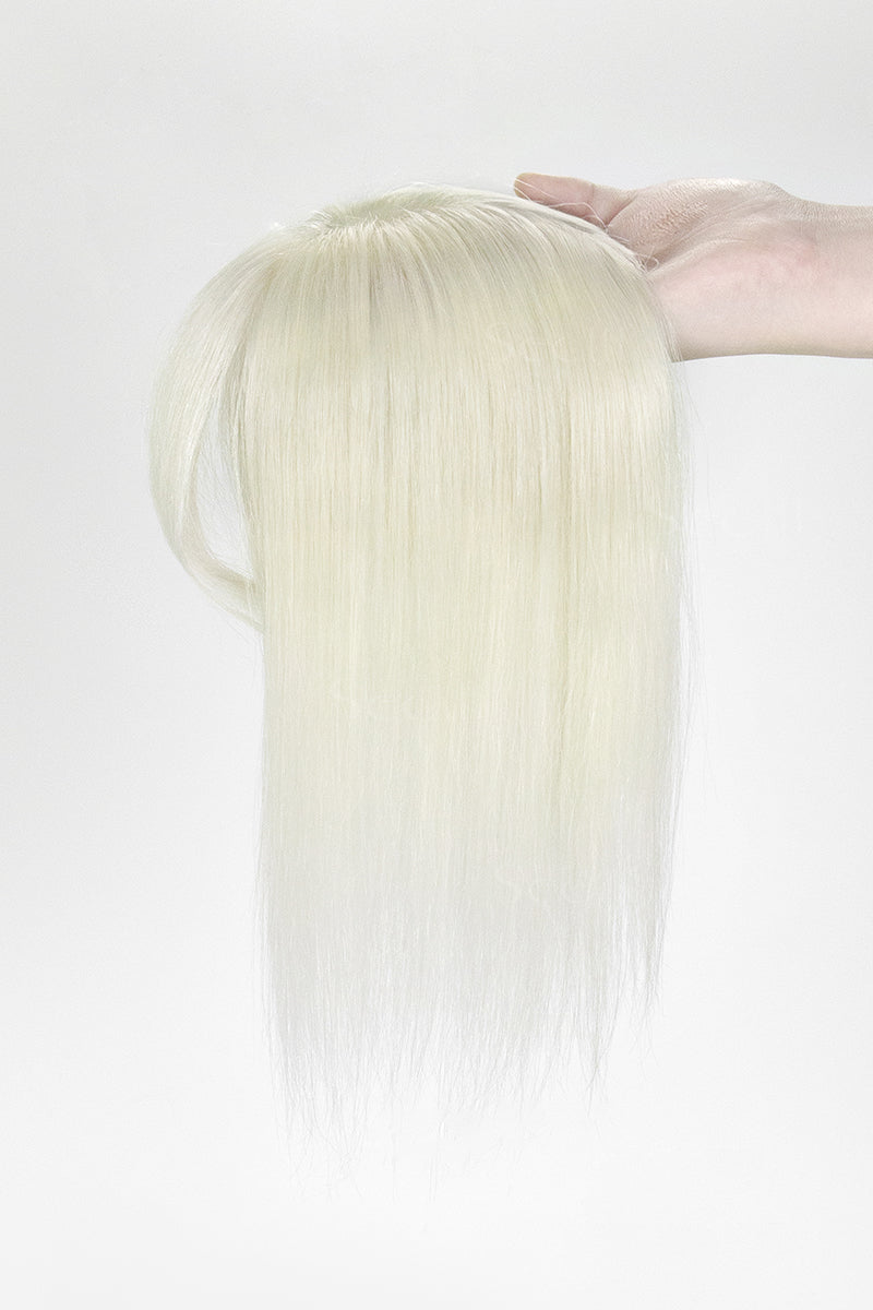 Blonde hair extension held by a hand against a white background