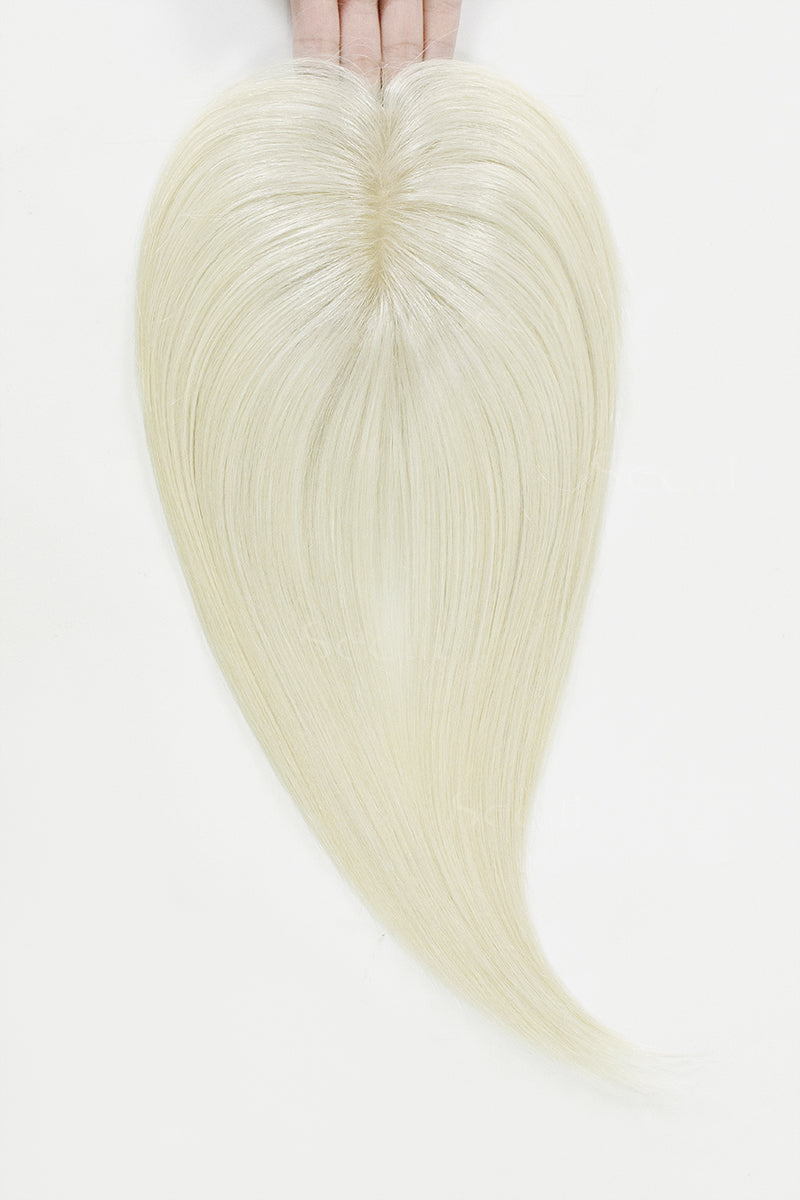 Blonde hair extensions held by hands on a white background