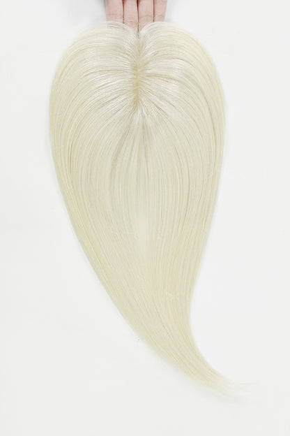 Blonde hair extensions held by hands on a white background