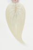Blonde hair extensions held by hands on a white background