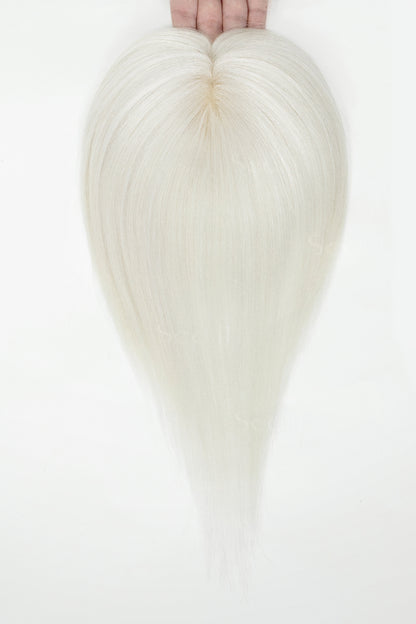 White topper held by hands against a white background