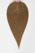 A heart-shaped hair extension or wig piece held at the top by fingers against a plain white background.