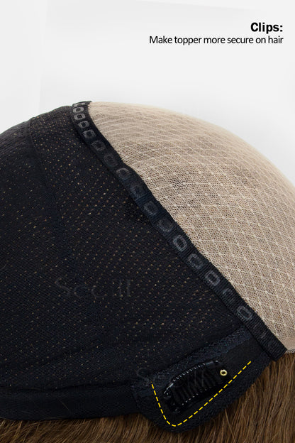 Close-up of a hairpiece with black and beige sections and clips on a white background.