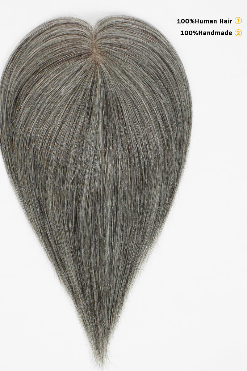 Medium grey hair topper laid flat with a center part and text highlighting handmade human hair construction.