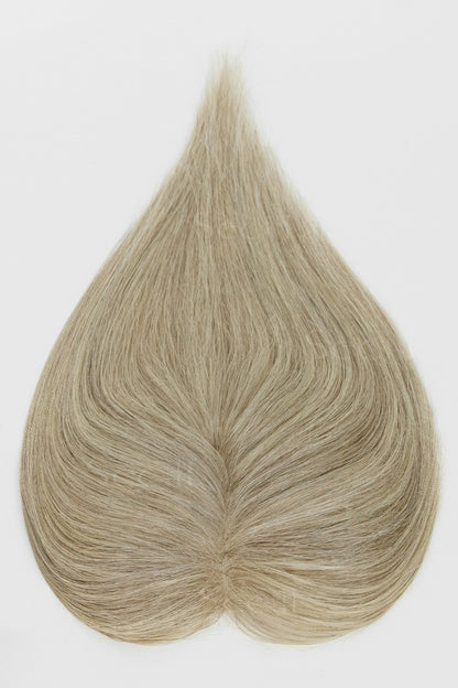 Overhead view of a beige blonde hair topper with strands spread out around the center part.