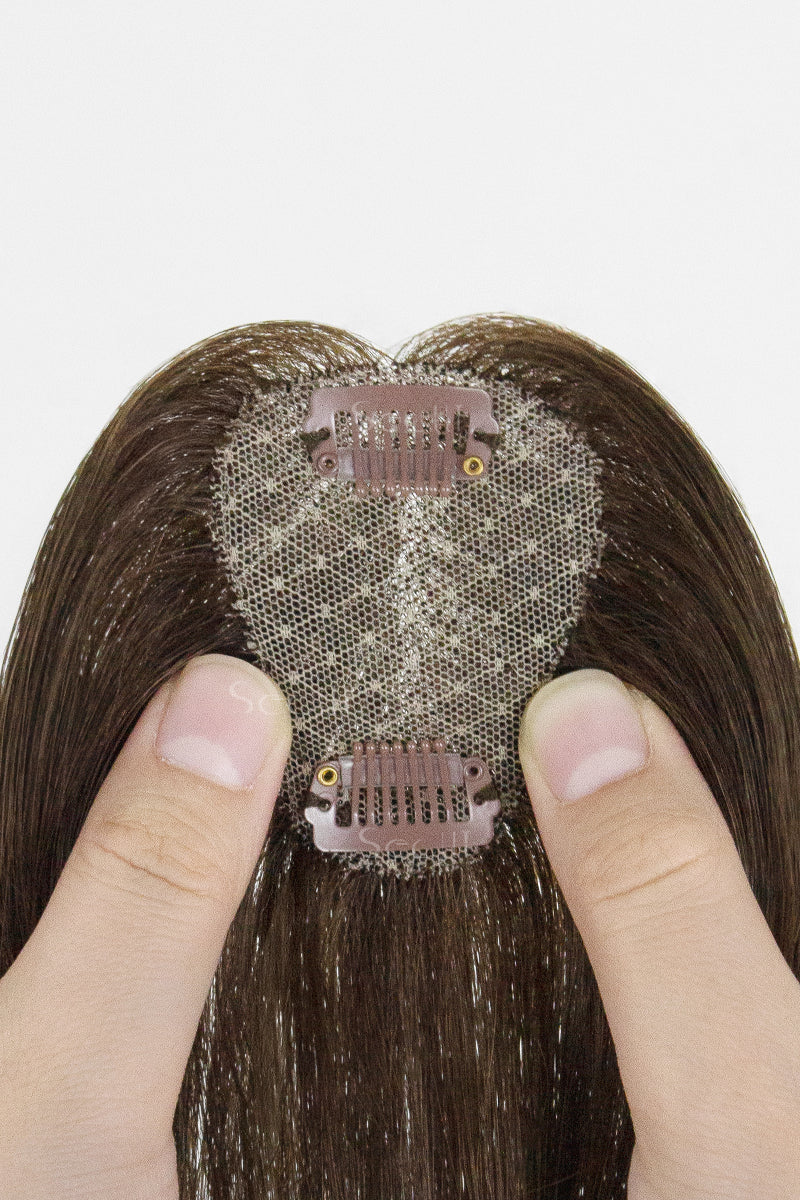 Hair topper with a clip on a white background
