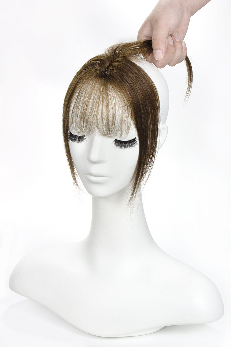 Brown hair topper with bangs on a mannequin head against a white background