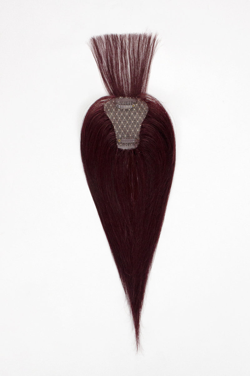 Brown hair topper with a clip on a white background