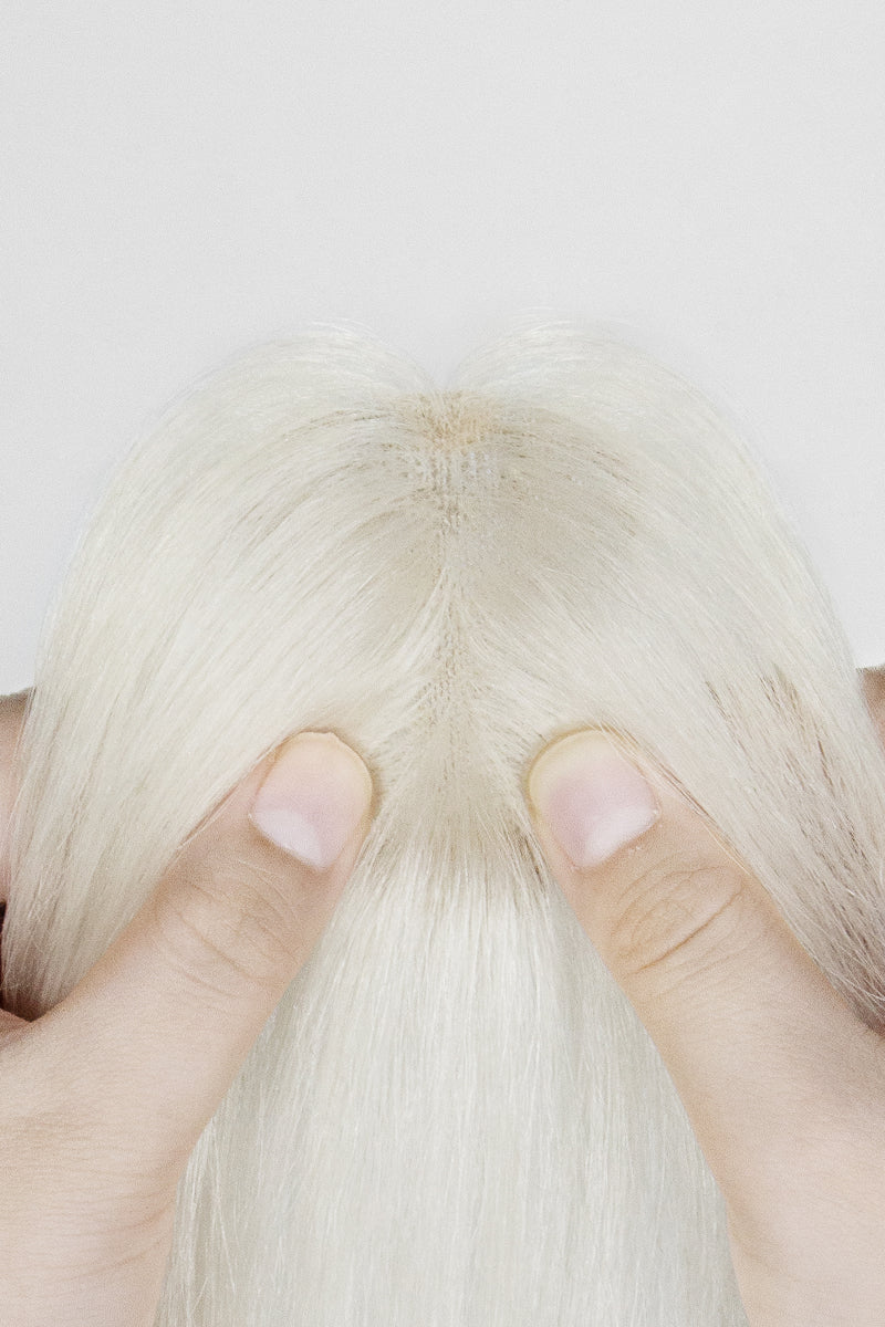 Close-up of a person holding a Magic Pixie Topper with Bangs 
