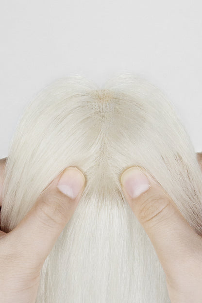 Close-up of a person holding a Magic Pixie Topper with Bangs 