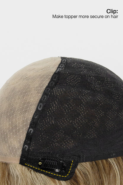 Close-up of a hairpiece with a clip on a white background