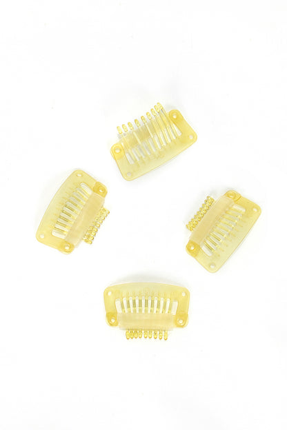 Four yellow hair combs on a white background