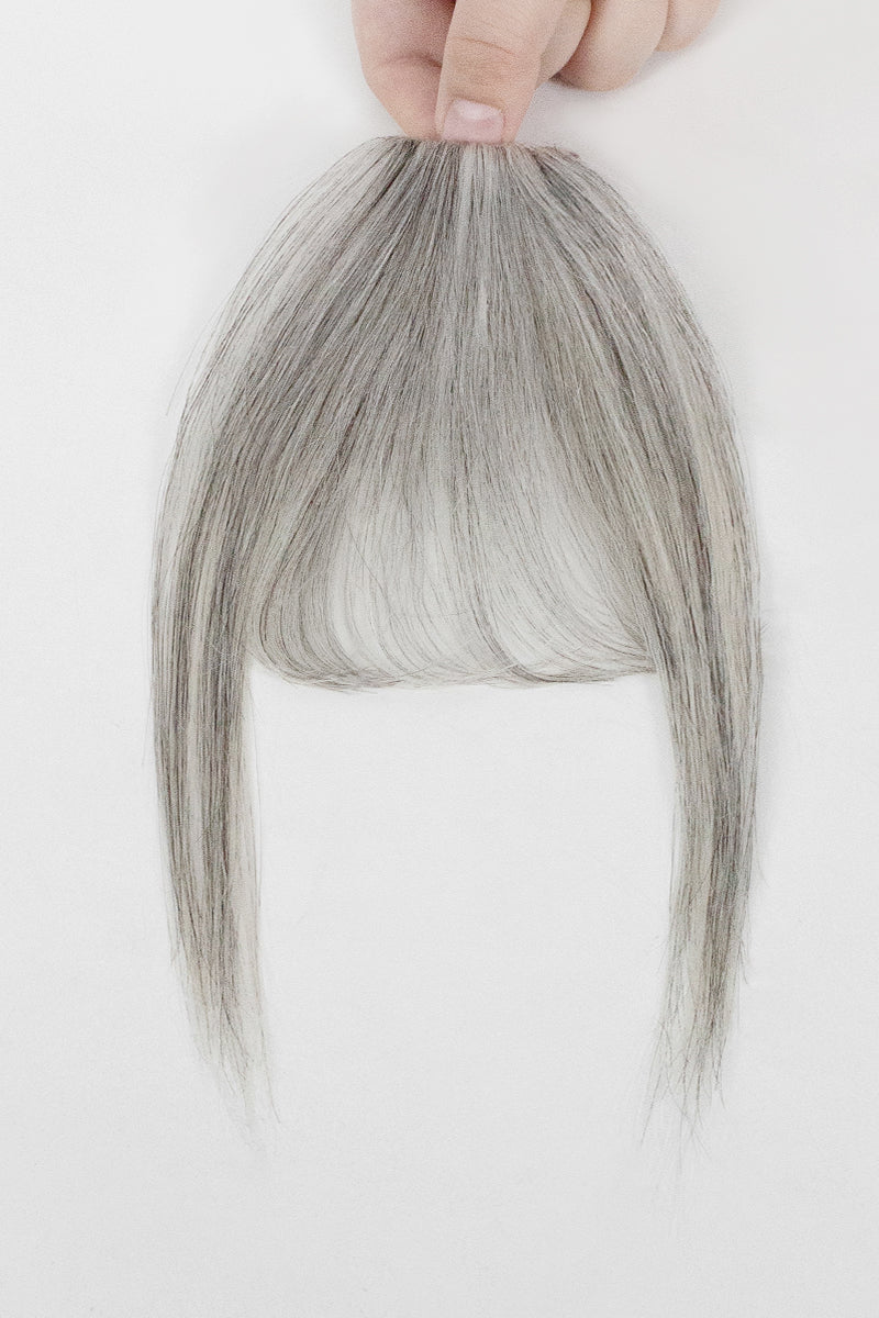 Gray hair bangs held by a hand on a white background
