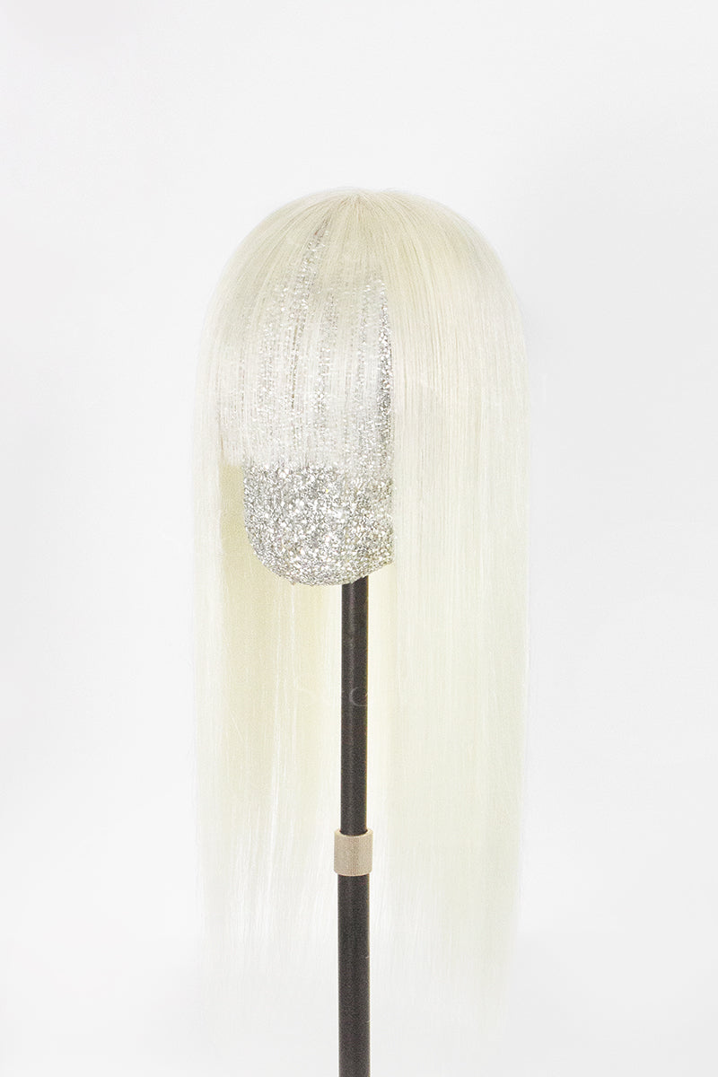 A long, straight platinum blonde wig with a textured silver glitter crown and a glittery silver lower section, displayed on a black mannequin stand against a white background.