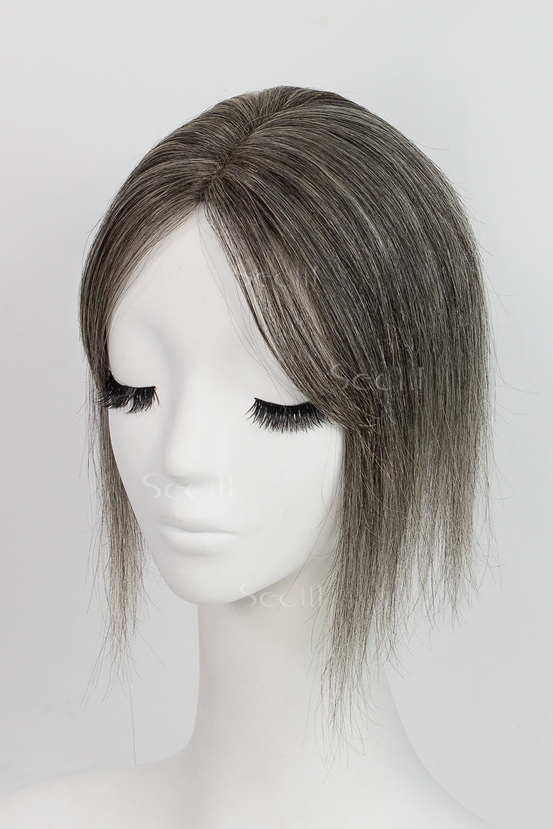 A mannequin head featuring a dark grey human hair topper with bangs.