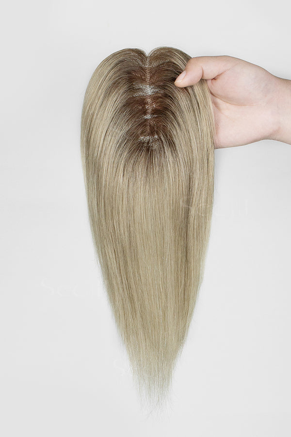 Mona Handmade Human Hair Topper Ombre Dark Root to Blonde #T2/M616 held by a hand on a white background