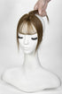 Mannequin head with a brown topper and bangs on a white background