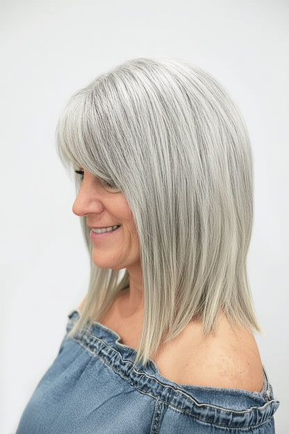 Woman wearing a sandy blonde short bob wig with full bangs, side profile view, striped top