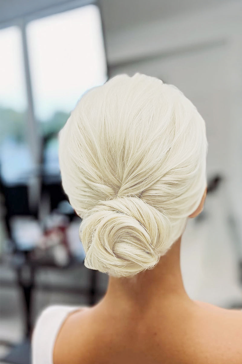 Back view of a white blonde low bun hairstyle on a mannequin.